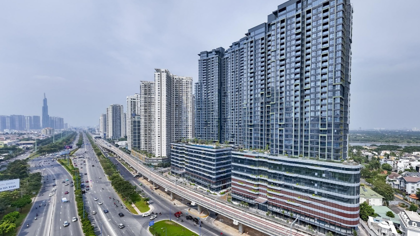Hình ảnh tuyến đường giao thông nhiều làn xe kết hợp đường sắt đô thị trên cao và các dự án căn hộ dọc tuyến. Phù hợp minh họa nội dung về tác động của giao thông đến khả năng kết nối và giá trị sử dụng bất động sản.