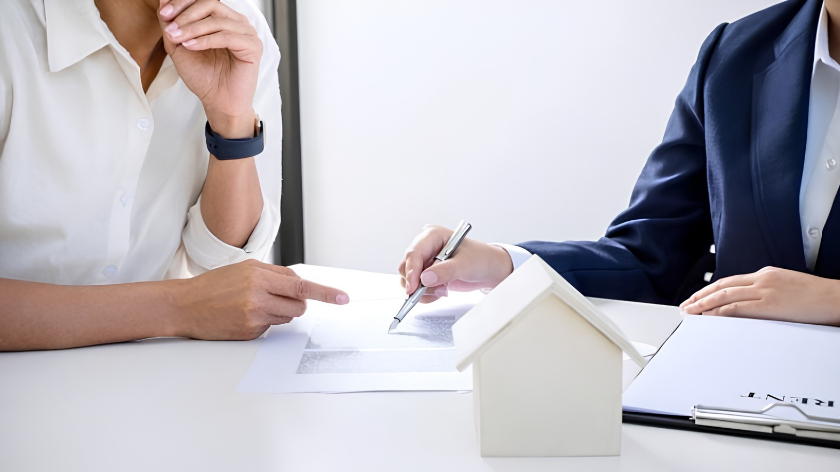 Hình ảnh hai bên trao đổi và rà soát giấy tờ trên bàn làm việc, phù hợp với phần hướng dẫn đọc hợp đồng đặt cọc, hợp đồng mua bán và những điều kiện giao dịch quan trọng.